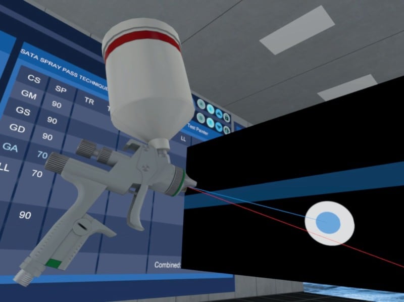 A close-up of a virtual spray gun in a training simulator, aimed at a surface displaying target graphics and performance metrics.