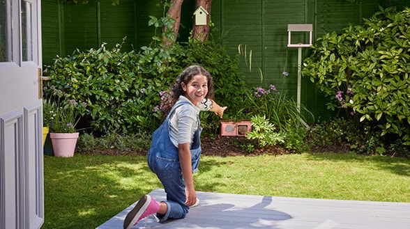 Image of a kid enjoying in their garden painted in Cuprinol