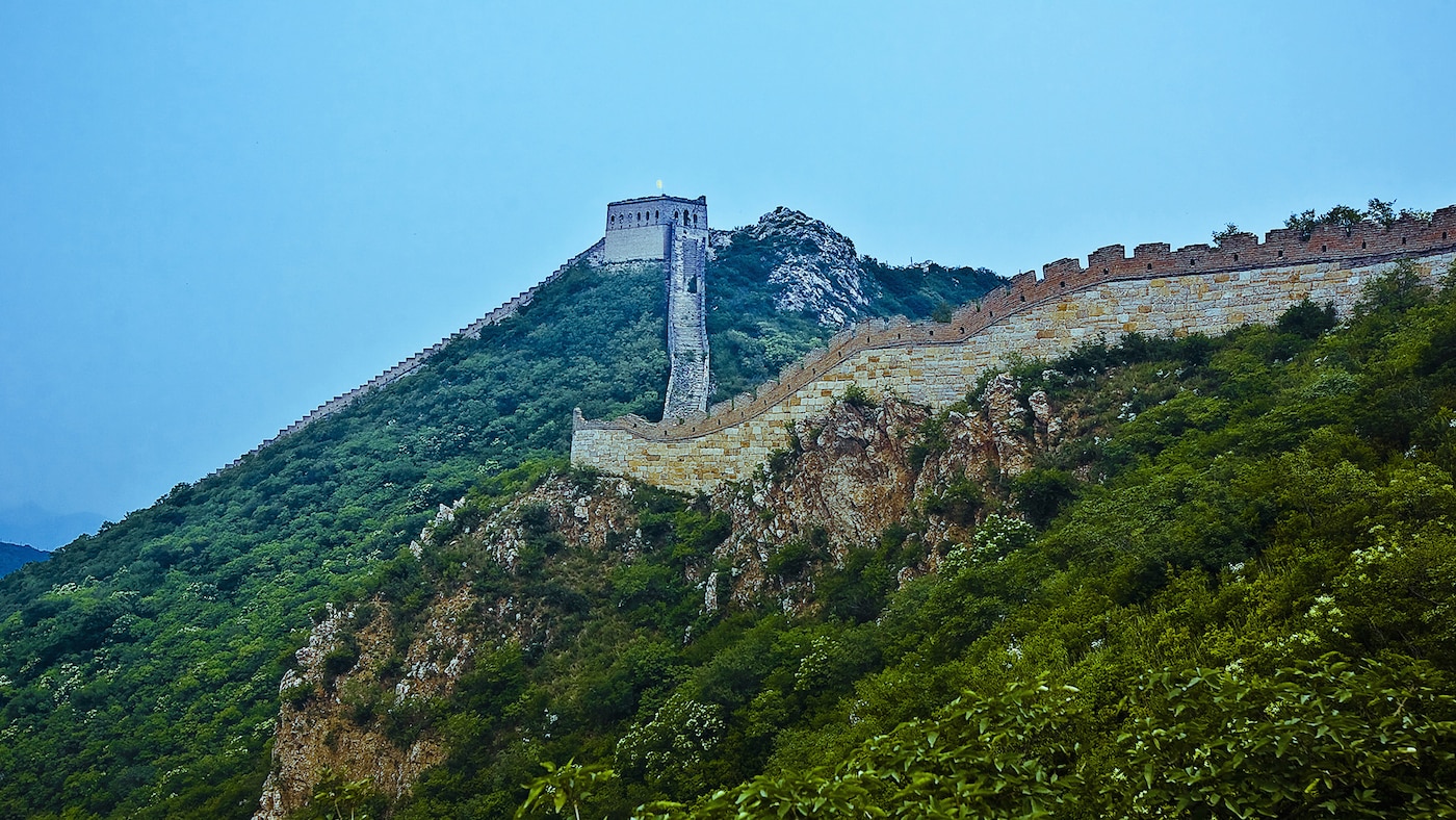 Great Wall of China looks magnificent against a blue and green landscape.
