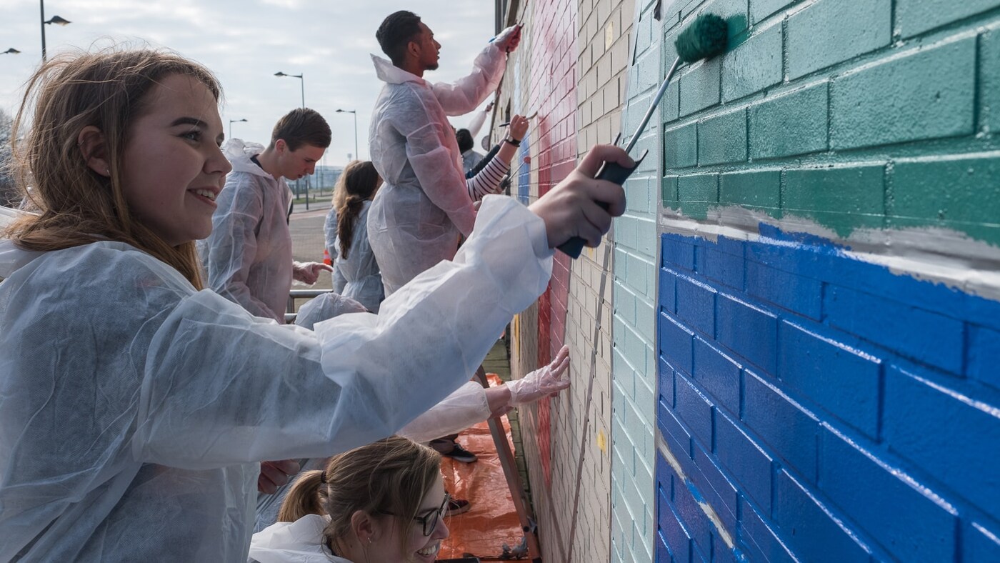 A woman painting a wall.