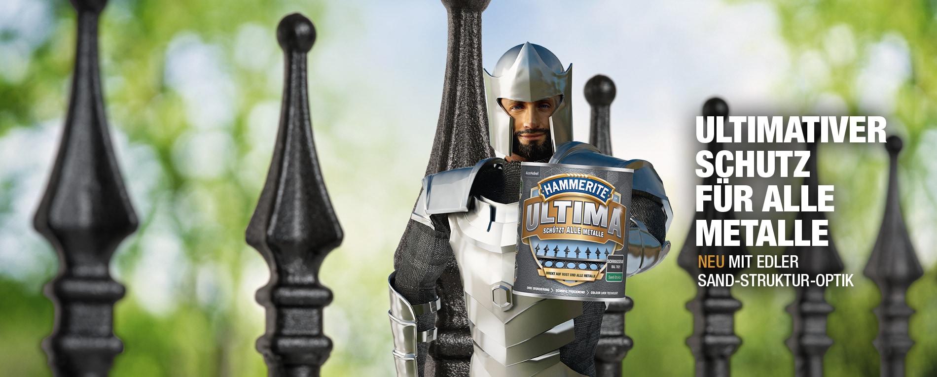 Ritter von Hammerite mit einer Dose Metallschutz-Lack mit neuer Sand-Struktur-Optik in der Hand vor einem Metallzaun