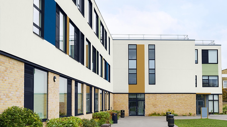 Skolebygning med farvefelter på neutral facade