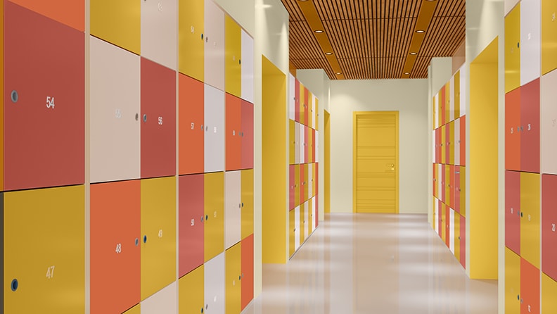 En korridor på en skole med aflåste skabe malet i forskellige farver