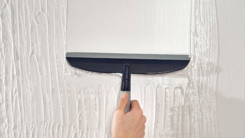 Spachtelmasse an einer Wand wird geglättet