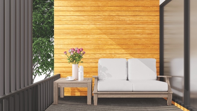 Mit einer Lasur im Farbton Kiefer gestrichene Holzfassade mit angerenzender Terrasse