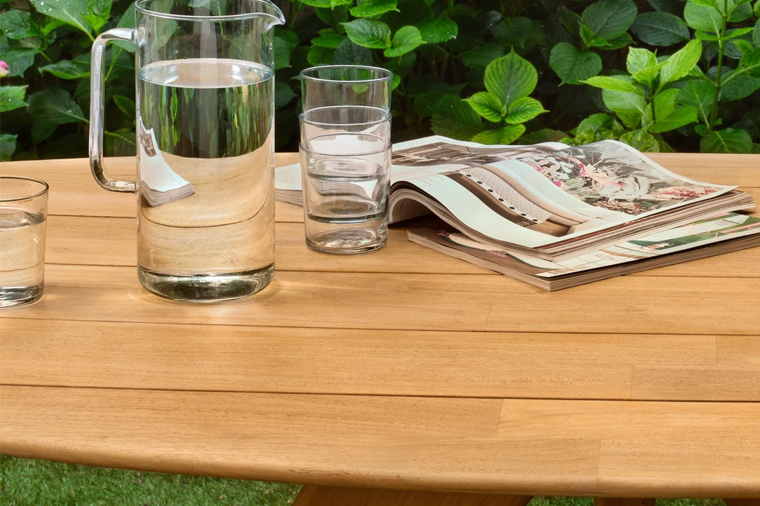Houten tafel met waterkan en glazen en tijdschrift