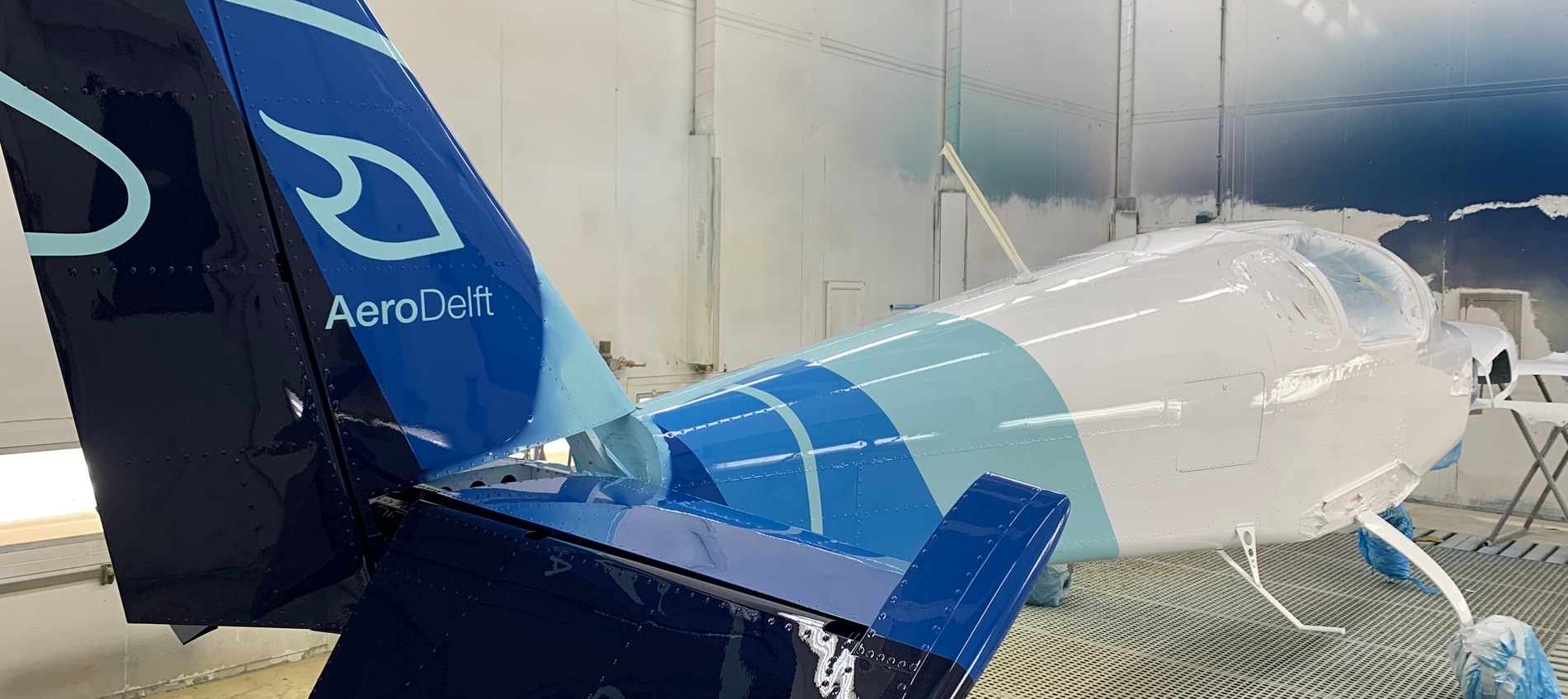 The finished design featuring layers of different blues with a symbol representing hydrogen and the name AeroDelft    visible on the tail.  