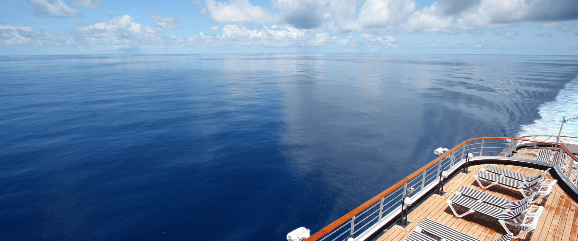 View of a vessel’s open deck overlooking calm ocean water.