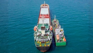Aerial view of two vessels alongside each other at sea during ship-to-ship bunkering.