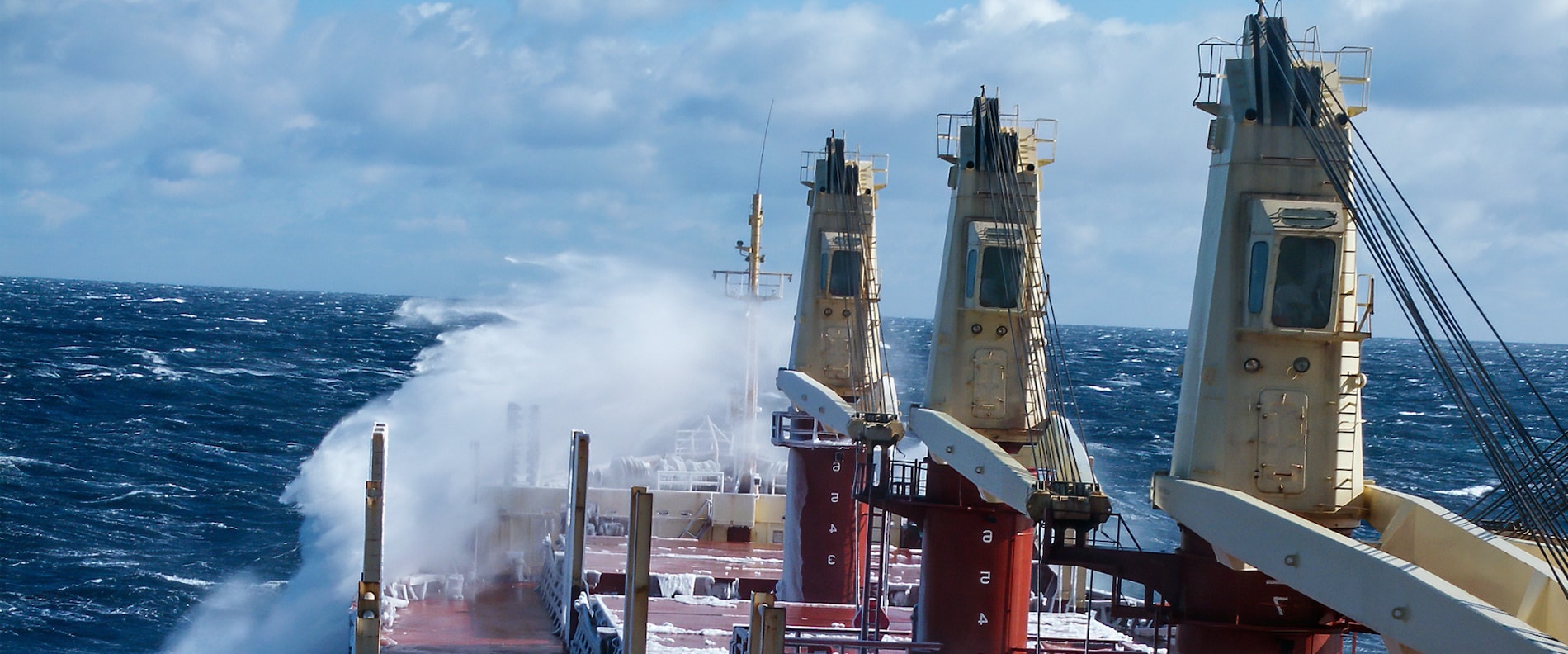 Bulk carrier deck at sea with waves breaking over the front