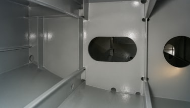 Interior steel compartment with protective coating applied to structural surfaces