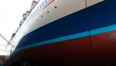 Ship in dry dock with freshly coated underwater hull