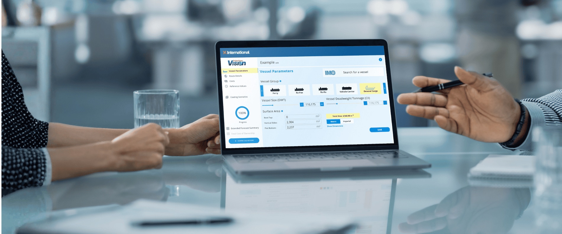 Two people review vessel performance data on a laptop screen displaying the Intertrac® Vision forecasting tool from International® Marine Coatings.