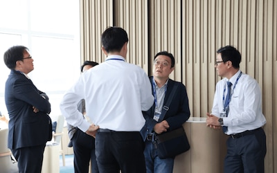 Industry partners and representatives discussing vessel performance and coating solutions.