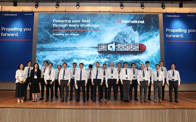 The International Marine Coatings team on stage at Kormarine 2025, beneath the Propelling You Forward campaign visuals.