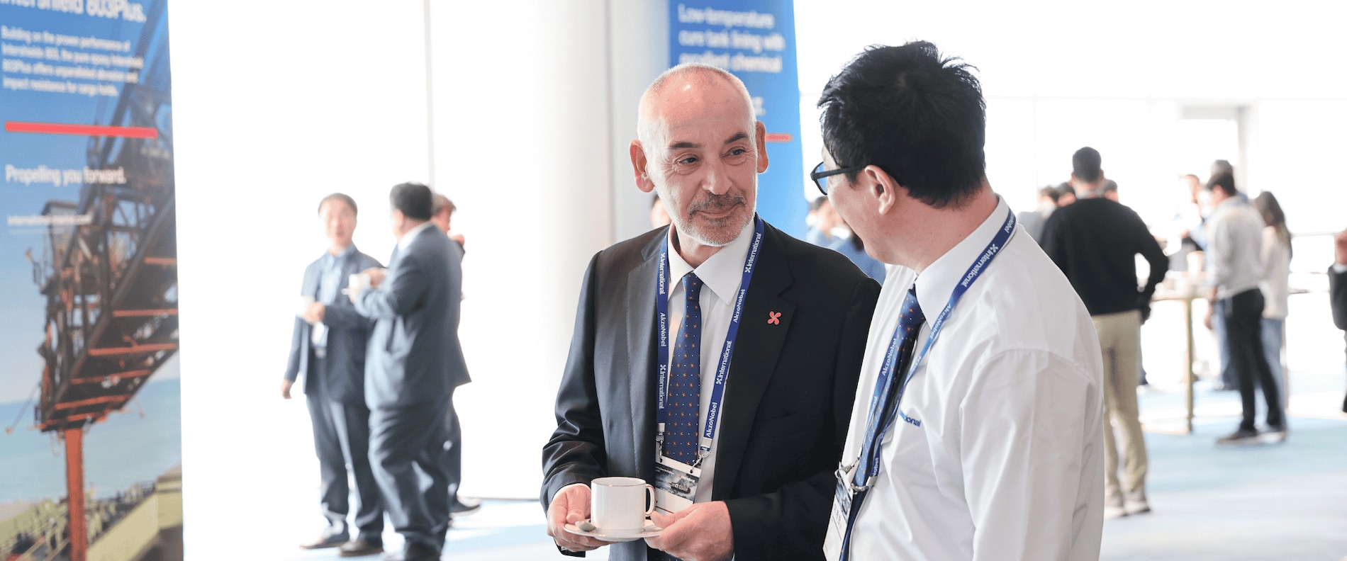 The International® marine coatings team on stage at Kormarine 2025, beneath the Propelling You Forward campaign visuals.