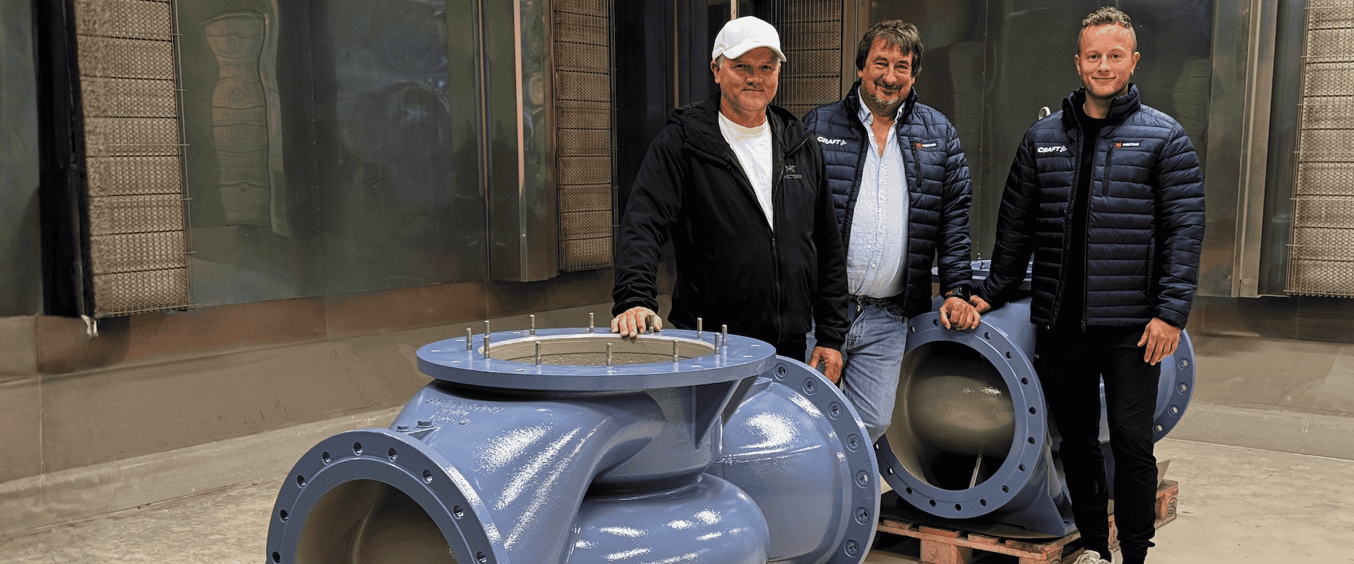 Team from Westing and Dalen Industriservice standing next to refurbished seawater pumps protected with Interline 984 coating from International Protective Coatings.