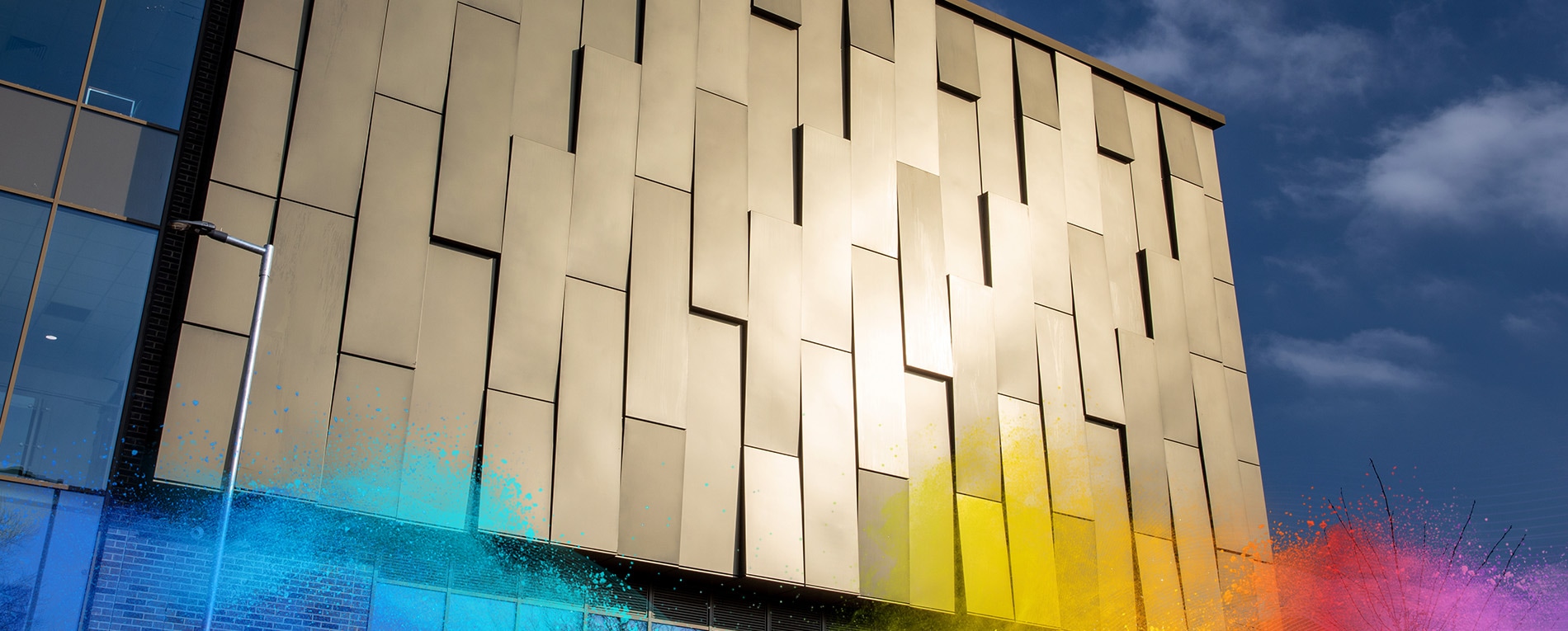 Modern building facade with golden anodic powder coatings panels under blue sky.