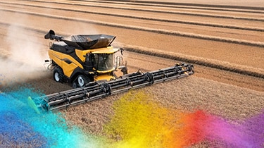 Yellow combine harvester operating in a wheat field