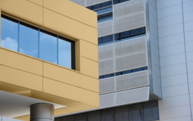 Modern building with golden powder-coated panels and blue sky