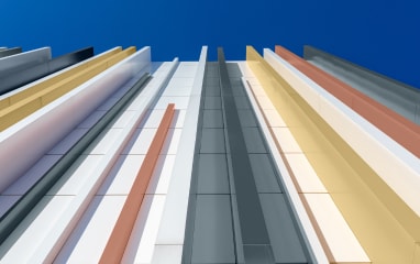 Upward view of skyscraper with golden powder-coated lines