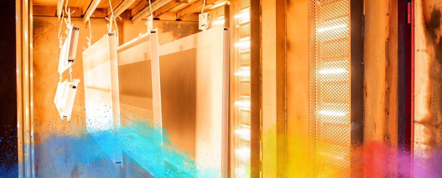 Powder-coated metal panels hanging in an industrial curing oven