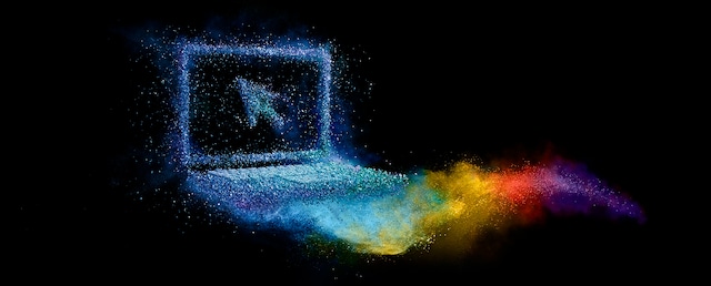 Laptop formed from colorful powder with rainbow trail on black