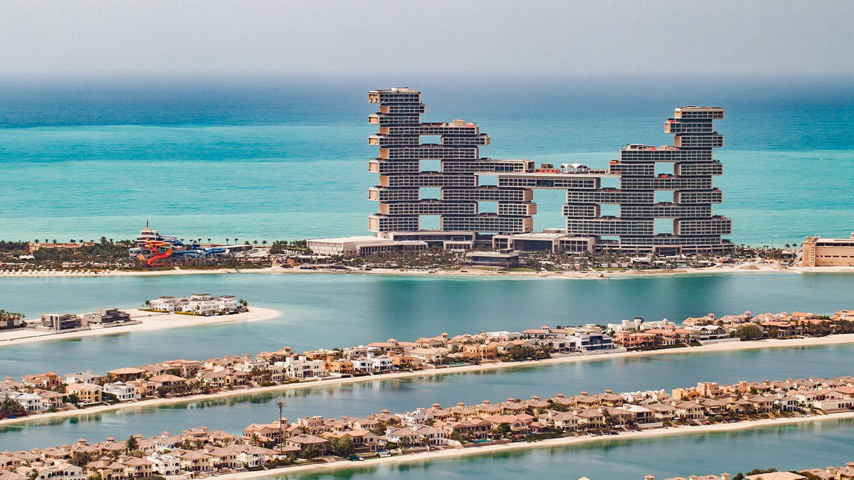 A luxurious resort on a palm-shaped island, overlooking the turquoise sea.