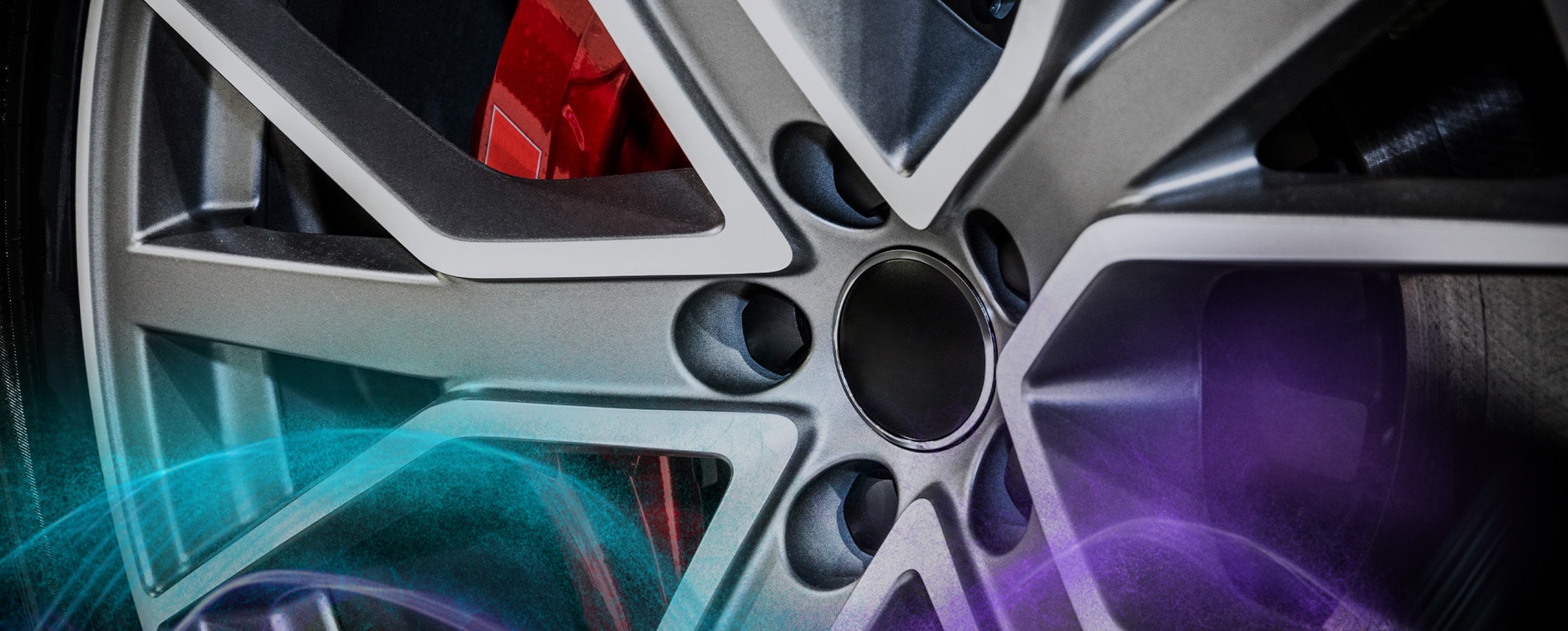 A coated alloy wheel surface with metallic finish and a red brake caliper.