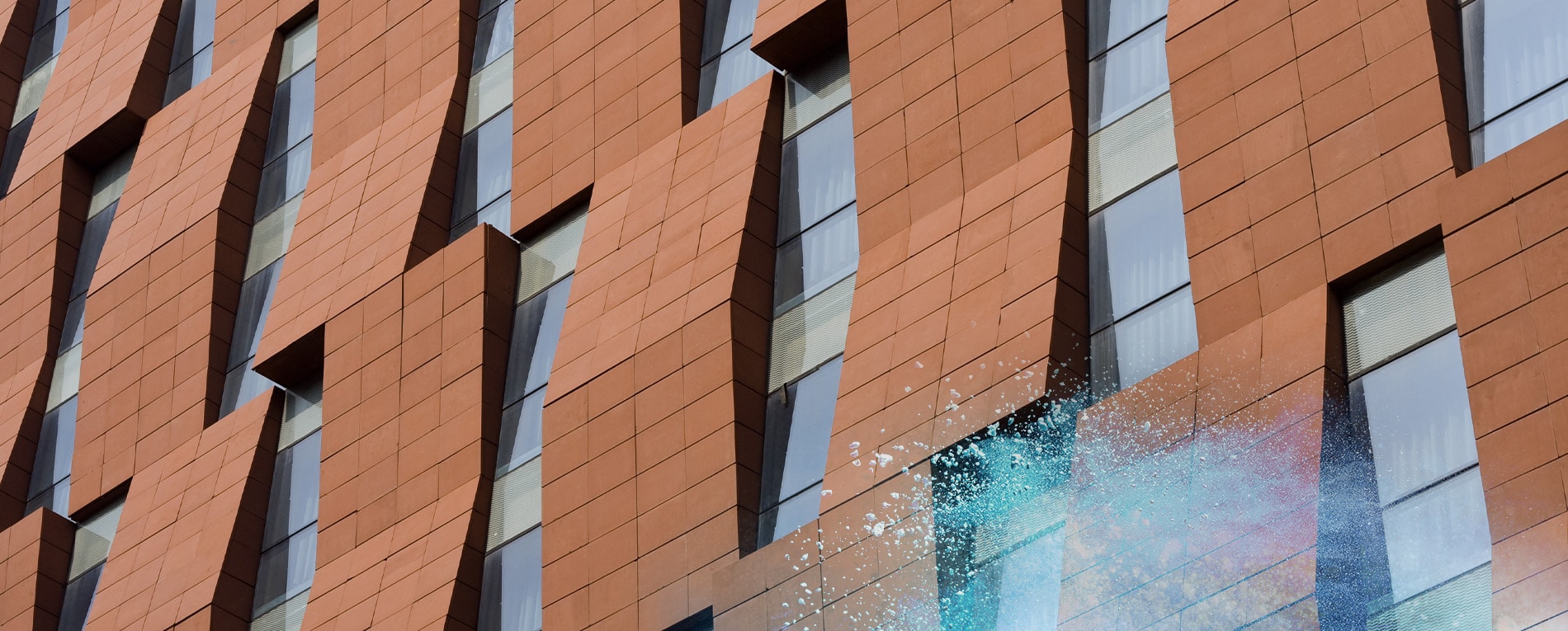 Fachada con recubrimiento en polvo bronce y paneles verticales en las ventanas