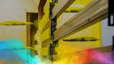 Powder coating process with yellow spray guns.