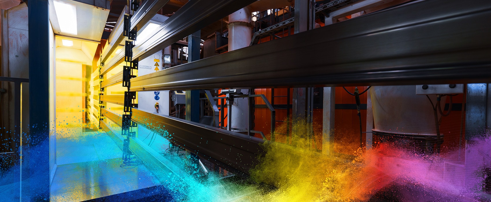 Metal components moving through a powder coating process in a factory setting