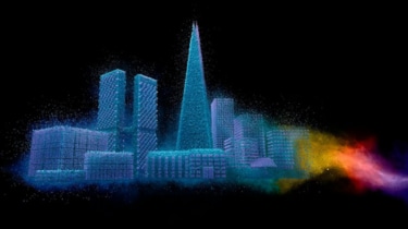 Powder-coated cityscape with colorful powder cloud on dark background