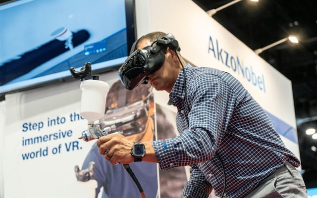 Visitor using AkzoNobel’s VR spray painting simulator demonstrating immersive coating technology at a trade show.