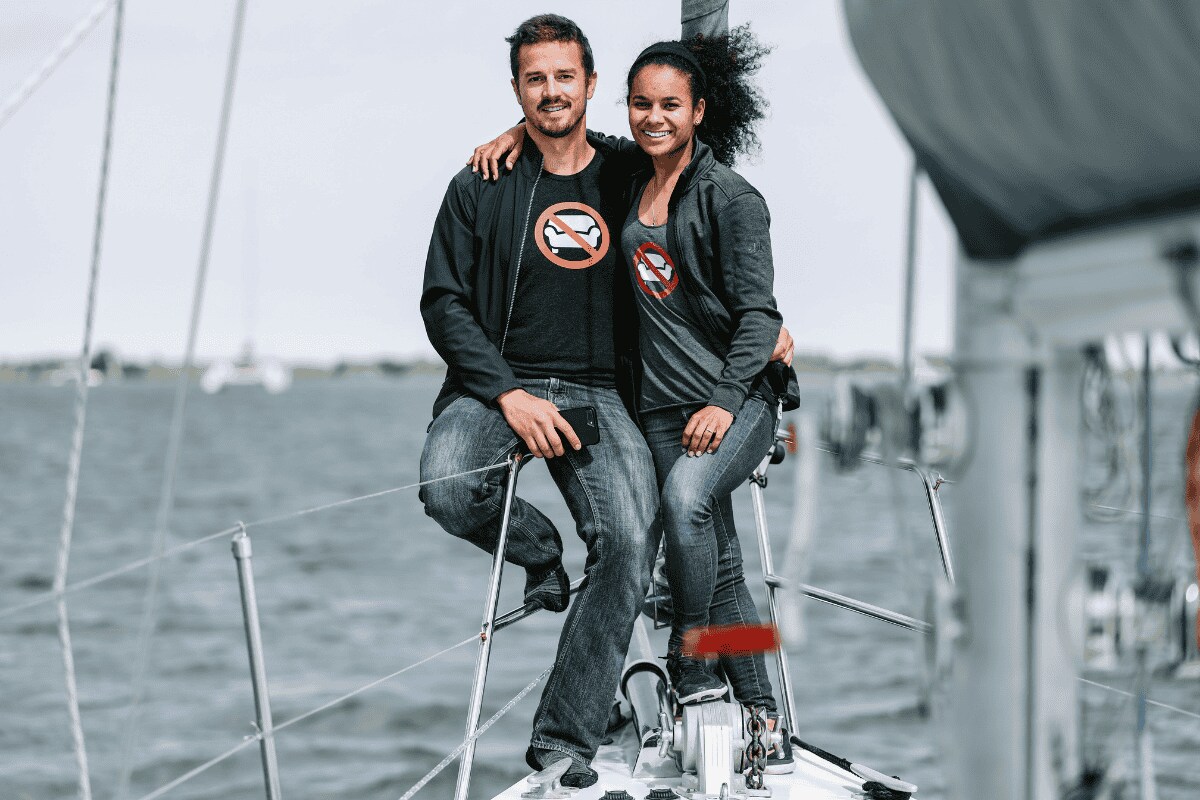 Dan and Kika from Sailing UMA smiling together on the bow of their sailboat