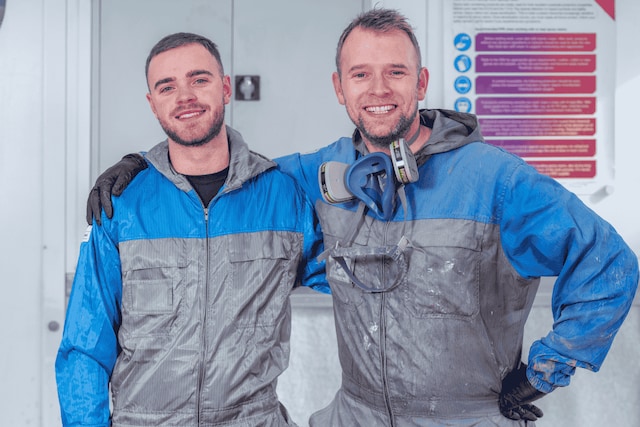 Applicators posing together in protective gear