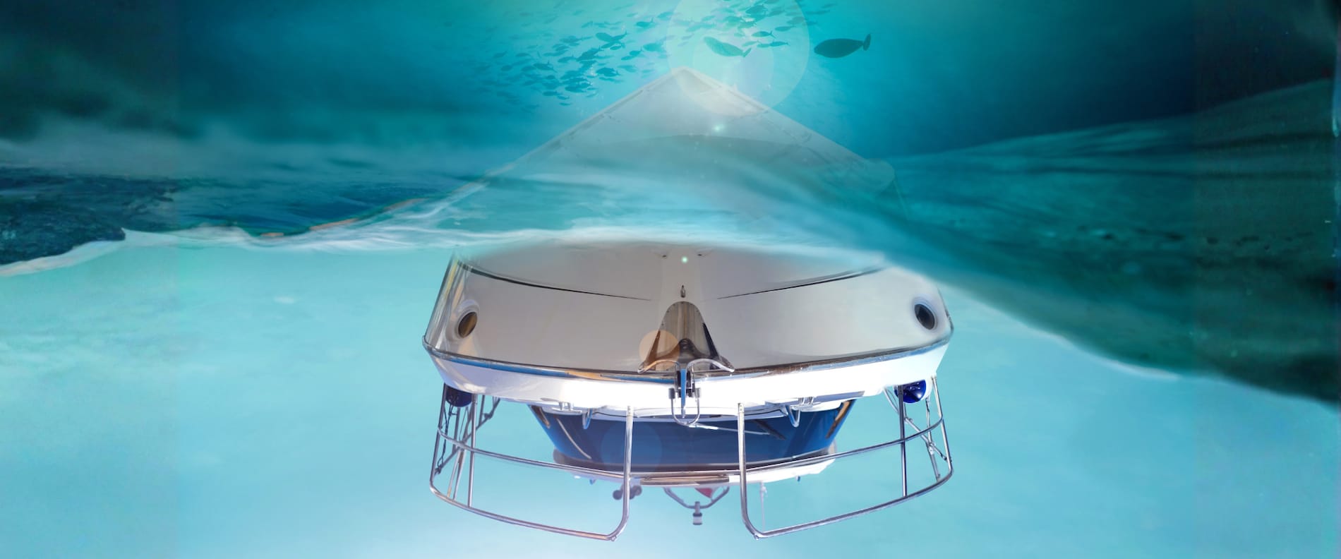 Undervattensbild av ett motorbåtsskrov sett under vattenlinjen, med klarblått vatten och ljusreflektioner på ytan.