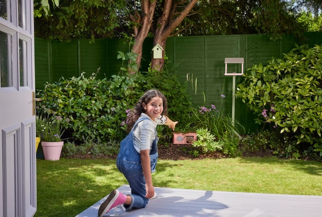 Image of a kid enjoying in their garden painted in Cuprinol