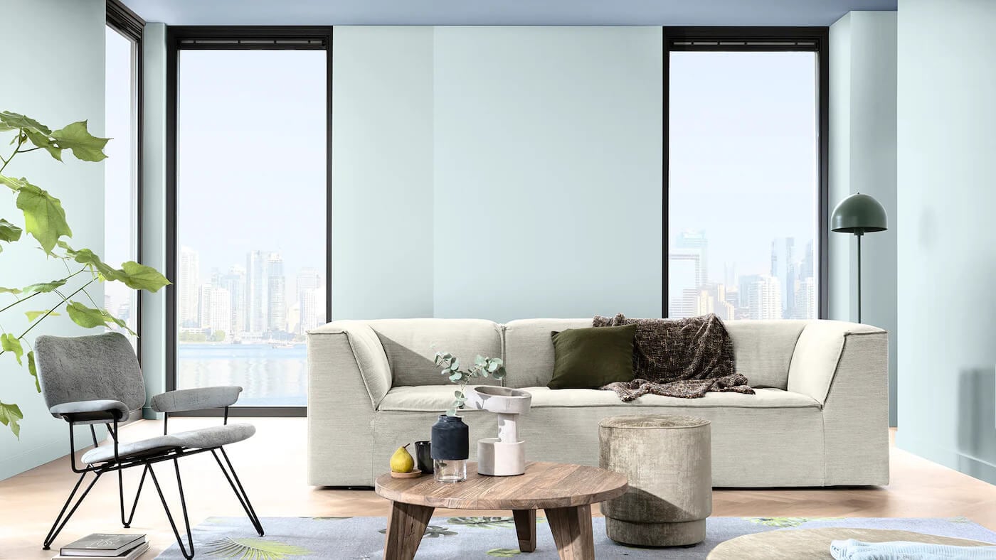 Sala de estar decorada com a cor Melodia Suave da Tintas Coral. O tom azul não fica apenas na parede como também se destaca no teto trazendo a sensação do céu dentro do seu lar. 