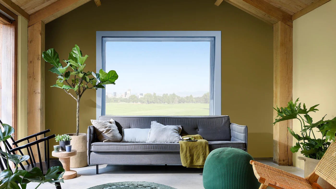 Sala de estar decorada com a cor Cáqui Intenso da Tintas Coral. O tom verde combinado com o azul traz a sensação de natureza e ar fresco se faz presente. 