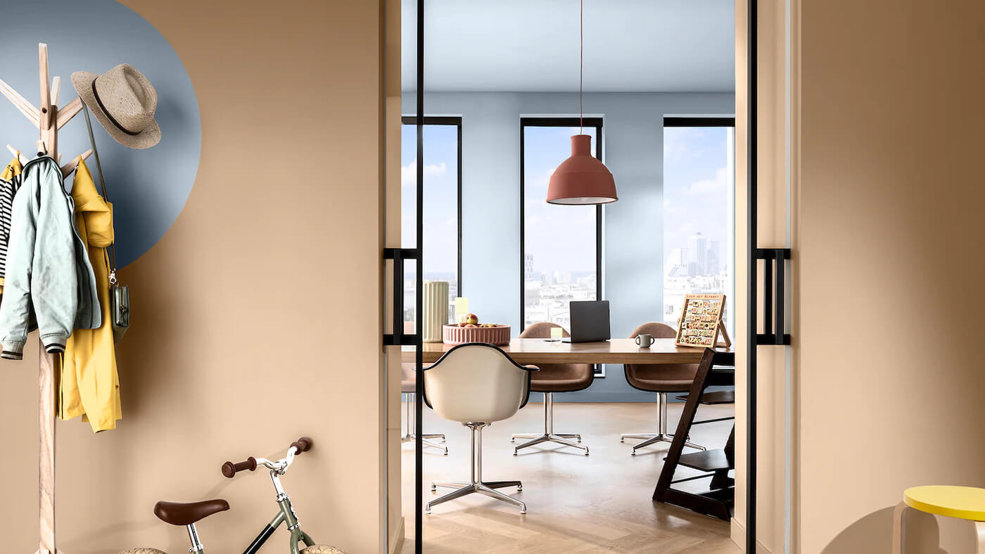 Corredor e escritório integrado decorados com as cores Creme Brulée e Melodia Suave da Tintas Coral. A integração do escritório e corredor é através das cores, um círculo no tom azul sobreposto ao tom neutro faz essa conexão.   