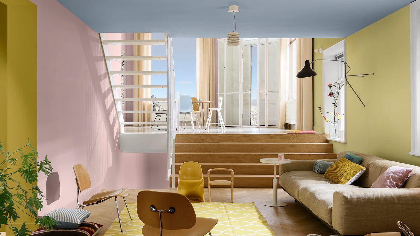 Sala de estar decorada com a cor Melodia Suave e paleta de Cores para uma Casa Versátil e Alegre da Tintas Coral. Os tons amarelos e rosas combinam perfeitamente com a cor do ano. 