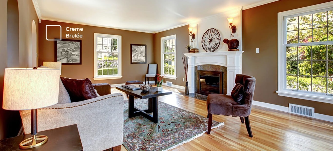 Sala de estar com parede em destaque na cor Creme Brulée da Tintas Coral. Uma cor marrom que se encaixou perfeitamente no ambiente e combina com a cor do sofá.