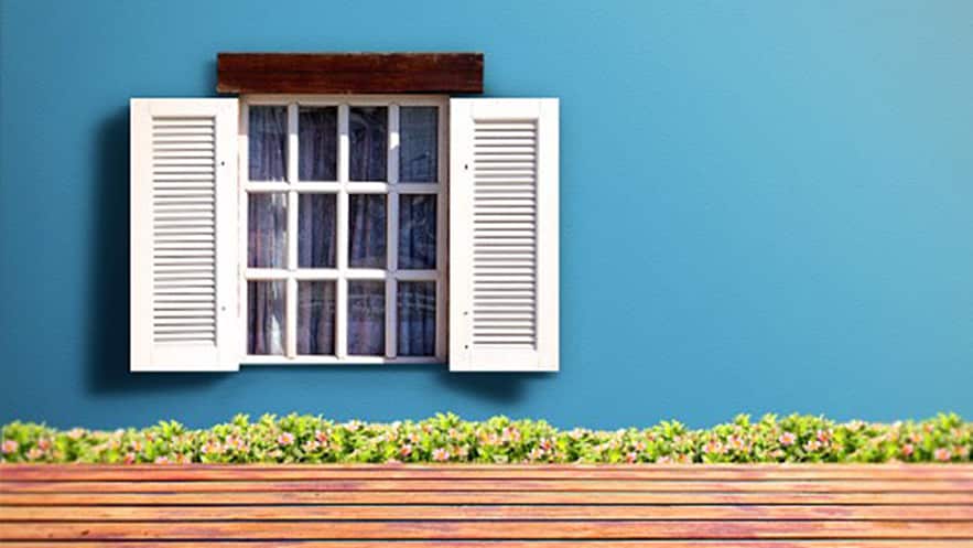 Fachada da casa com uma janela e parede pintada em tons de azul.