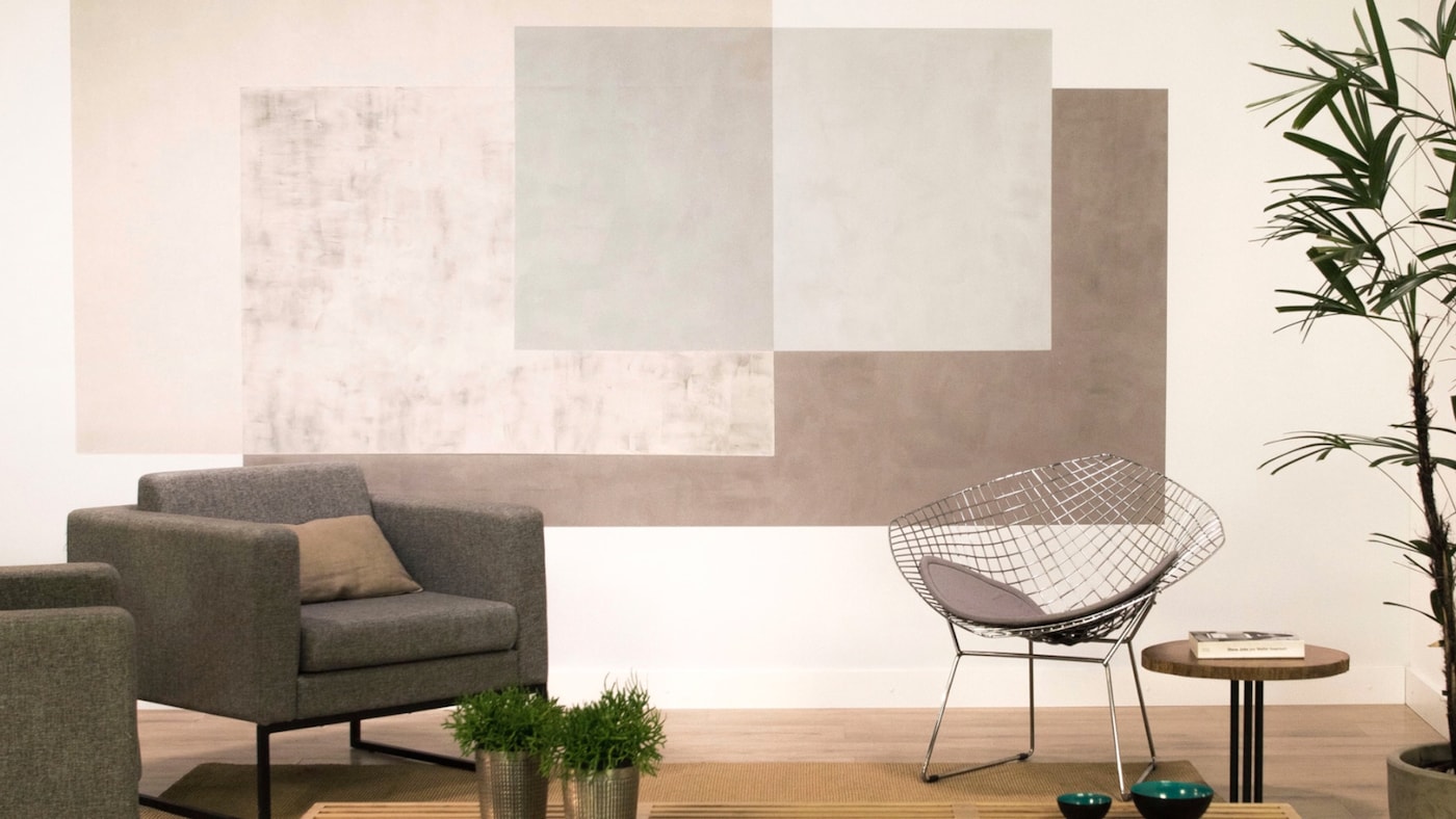Ambiente com parede decoradas com efeito quadrados sobrepostos.