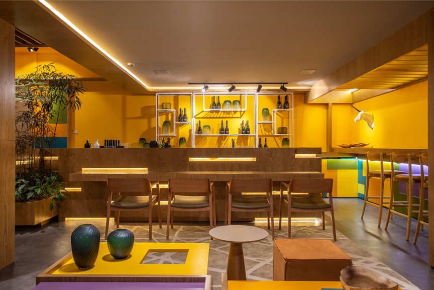 Ambiente com sala e bar decorado casacor Paraná com tons de amarelo.