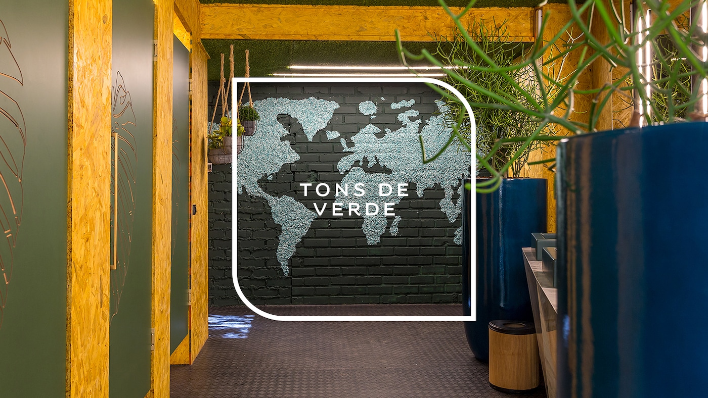 Ambiente externo decorado com parede mapa mundi com tons de verde.