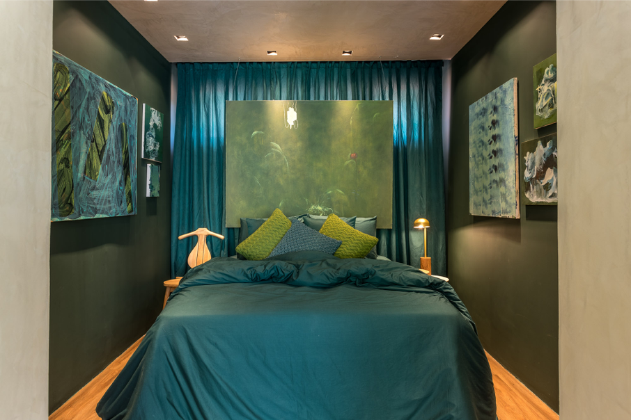 Quarto decorado com parede em tons de verde.