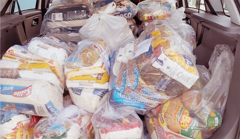 Porta malas de um carro cheio de arrecadações de alimentos.