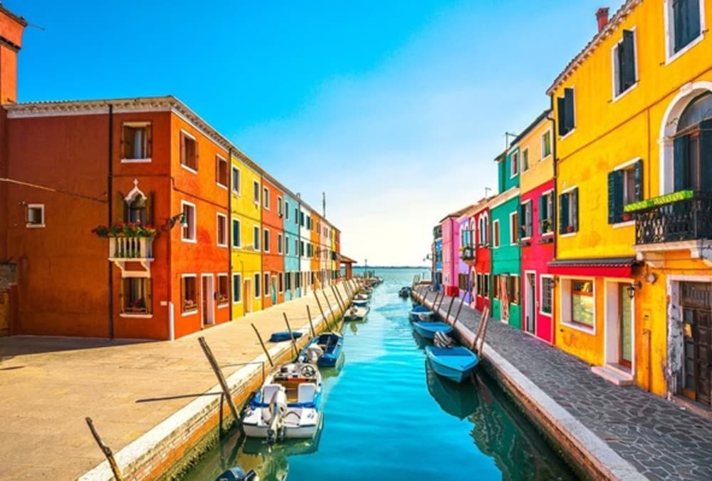 Rua da cidade de Burano na Itália com casas de fachadas coloridas